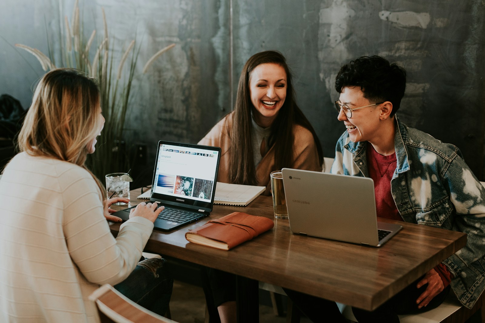 Studierende arbeiten gemeinsam an Laptops